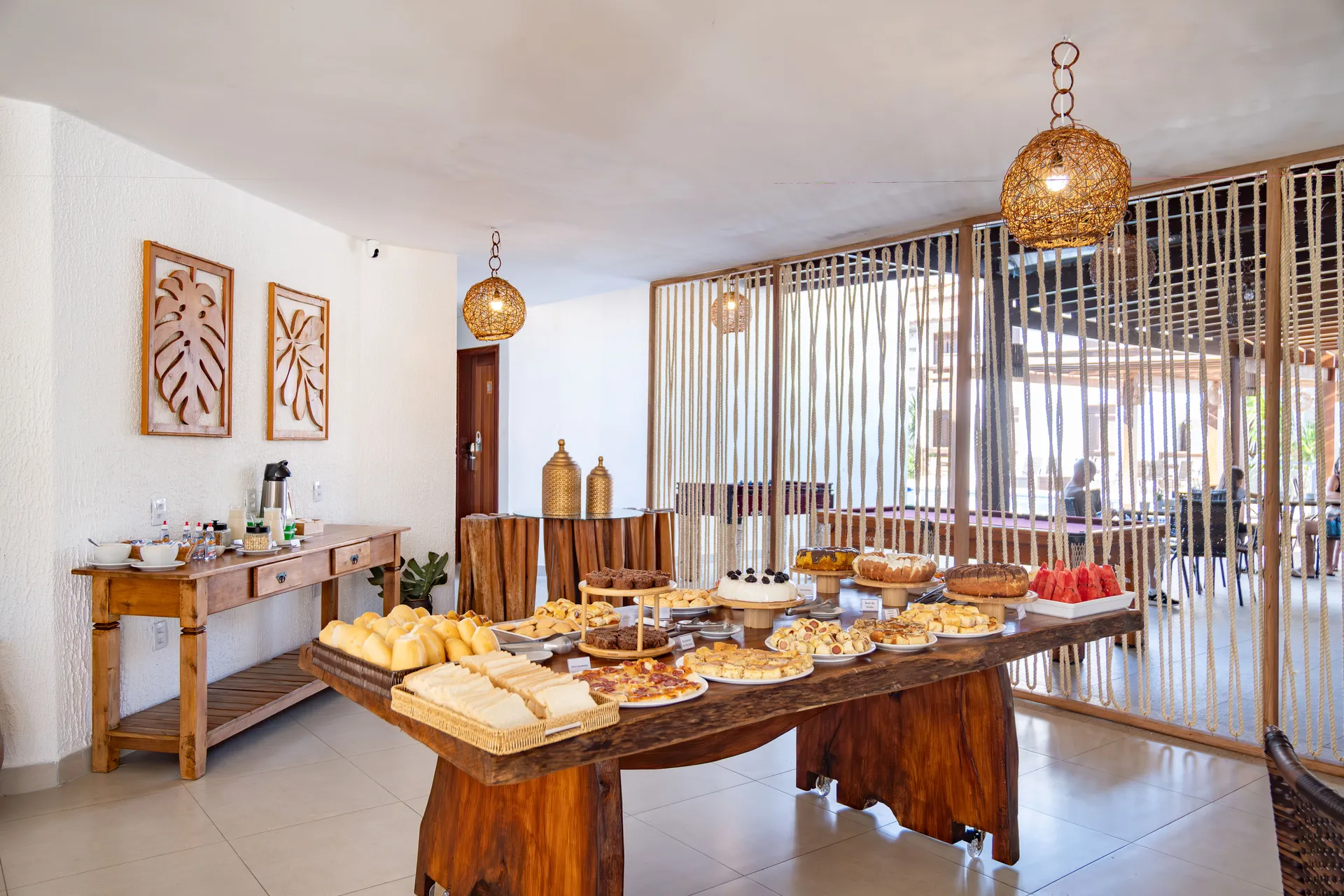 Buffet do restaurante do Hotel Encantos de Itaperapuã com bolos e pães